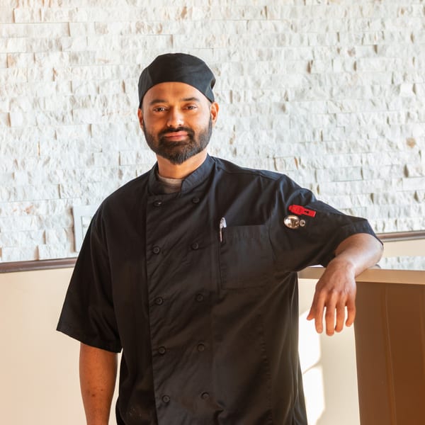 Haldi Fine Indian Cuisine's chef, a man with a beard, wearing a black chef's coat and cap.